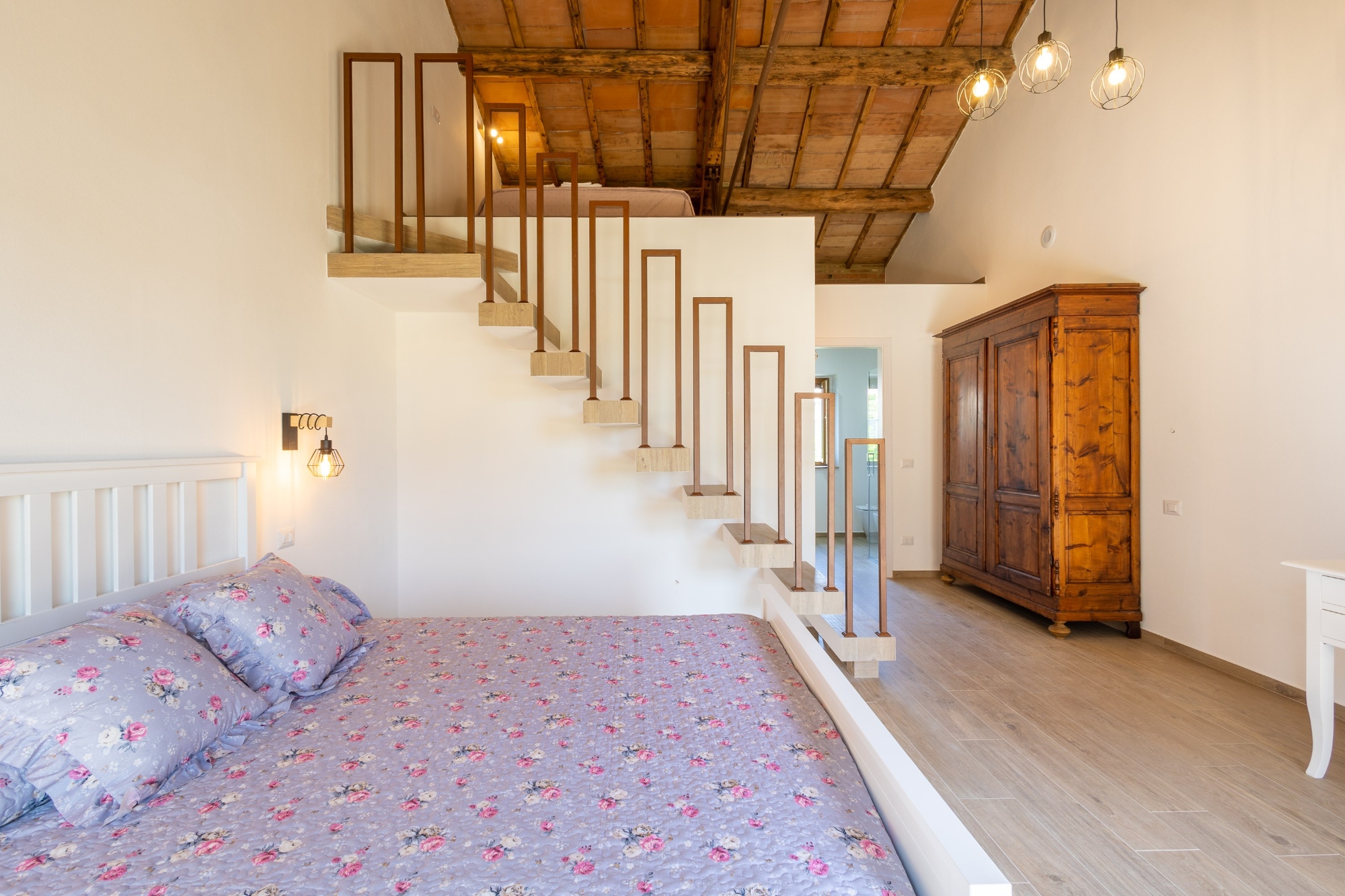 Camera da letto di charme con soppalco e soffitto a travi