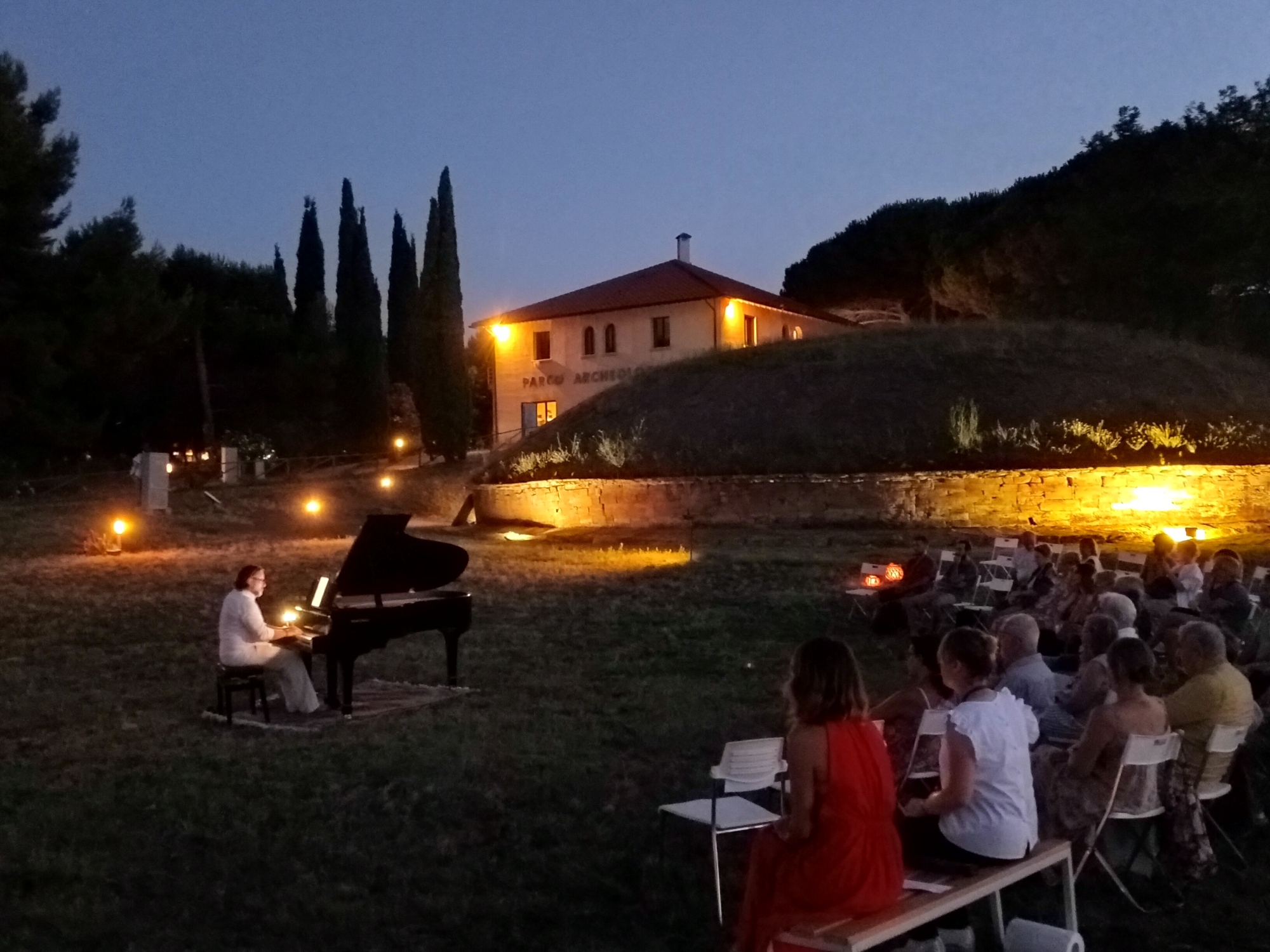 Immagine di un pianista che suona davanti al pubblico al crepuscolo