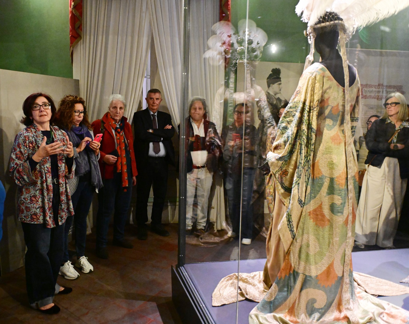 Visitatori in visita guidata al Puccini Museum di Lucca osservano il costume di scena della Turandot esposto in teca