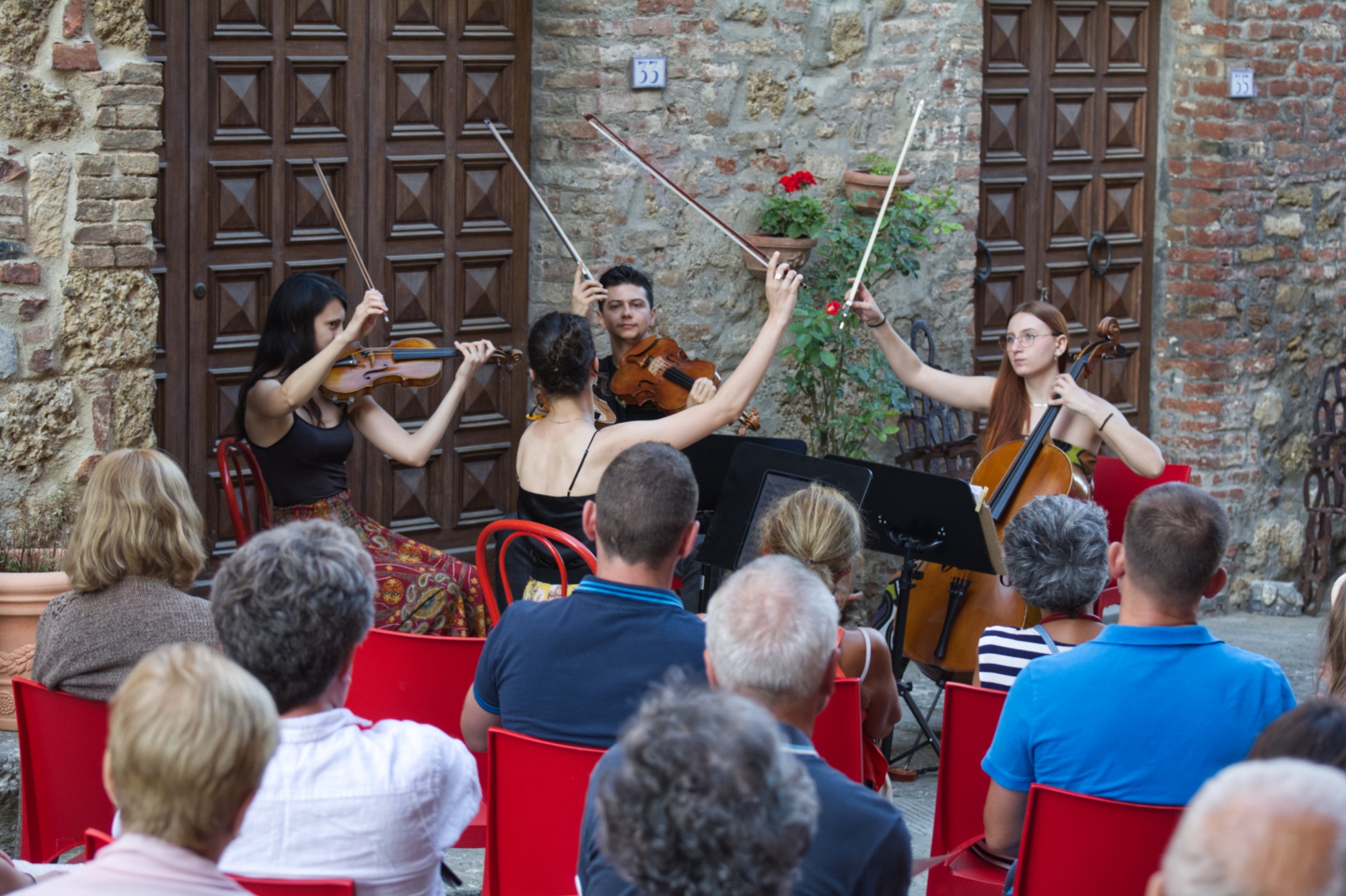 Image of a group of young musicians playing with their bows raised