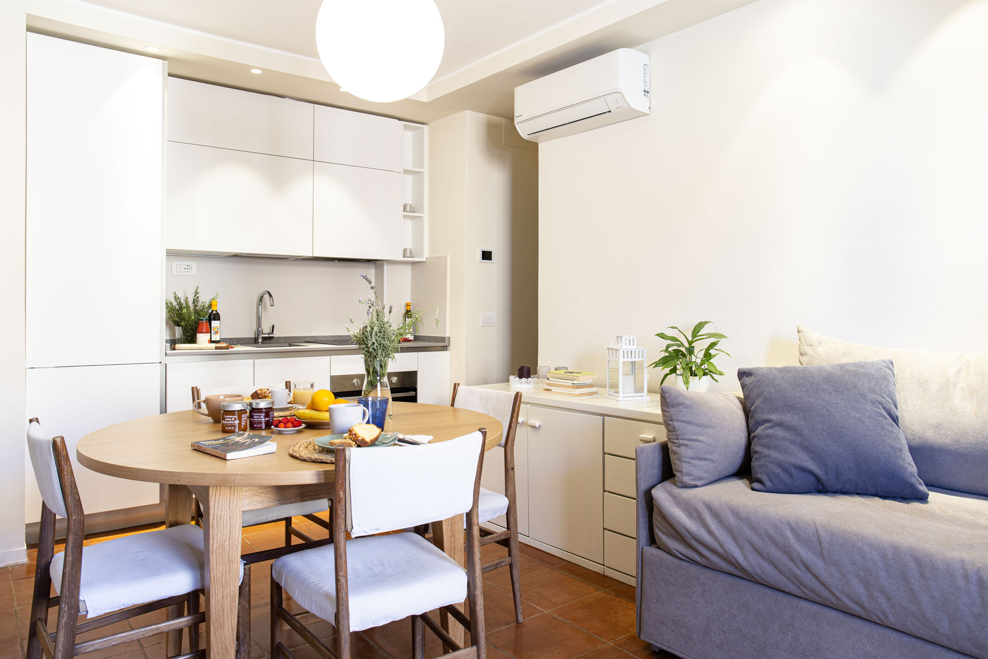 Modern open-plan living area with kitchen and sofa in a Florence apartment