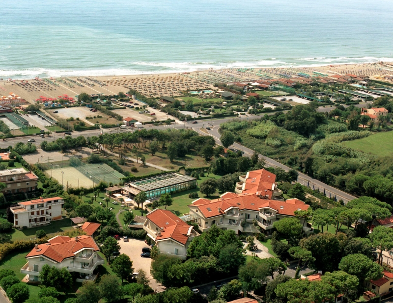 Veduta aerea dall'alto di Hotel Villa Undulna con tetti rossi, campi da tennis e spiaggia attrezzata a Cinquale