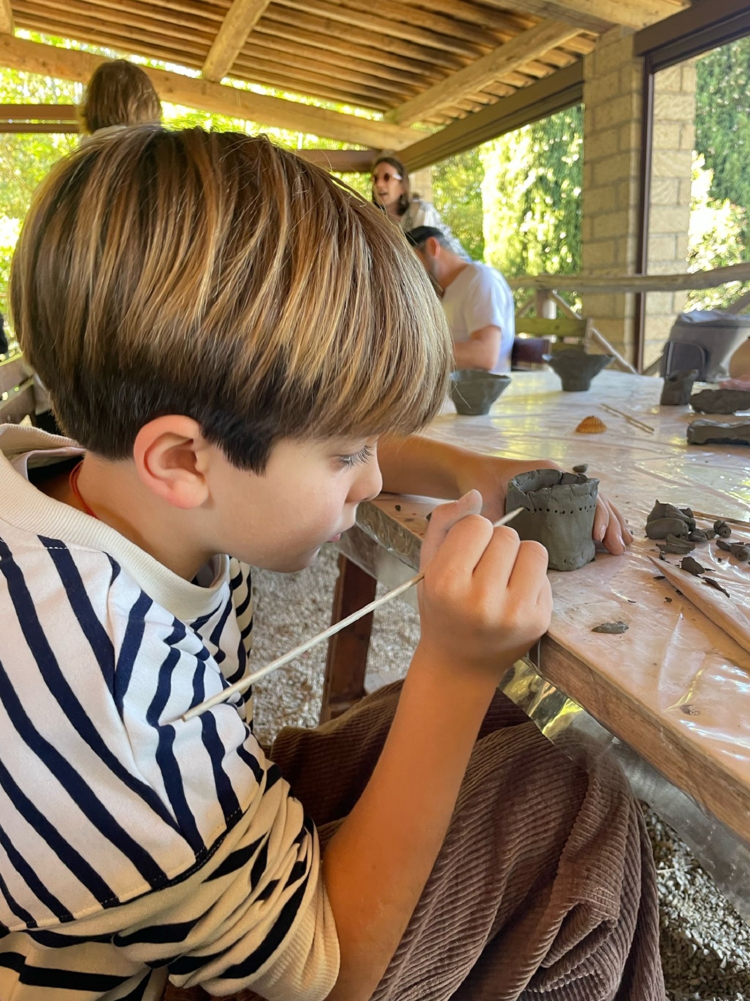 Nella bottega del vasaio, un bambino che partecipa al laboratorio