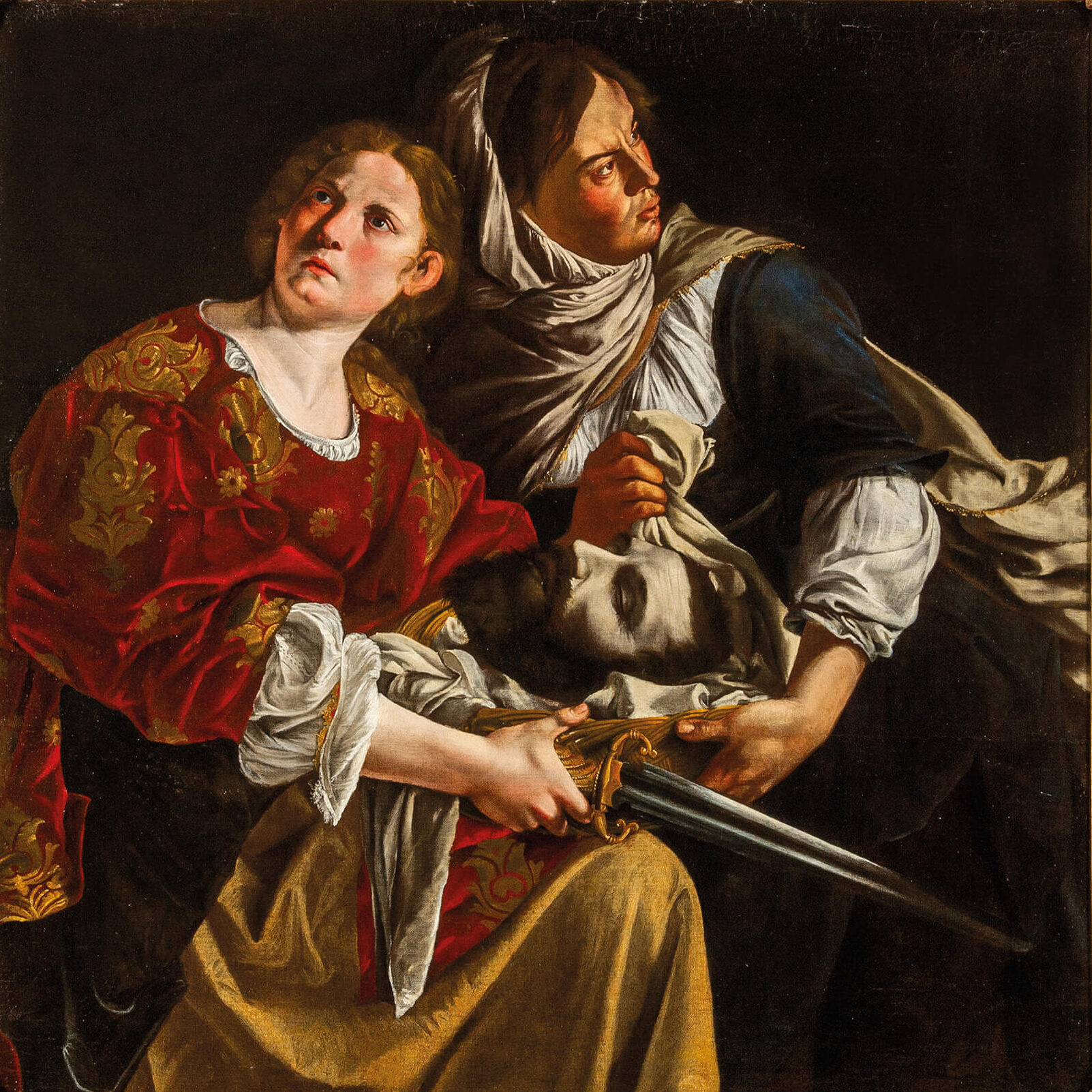 Giuditta e la sua ancella, dipinto di Artemisia Gentileschi: due donne con la testa di Oloferne, illuminate su uno sfondo scuro.