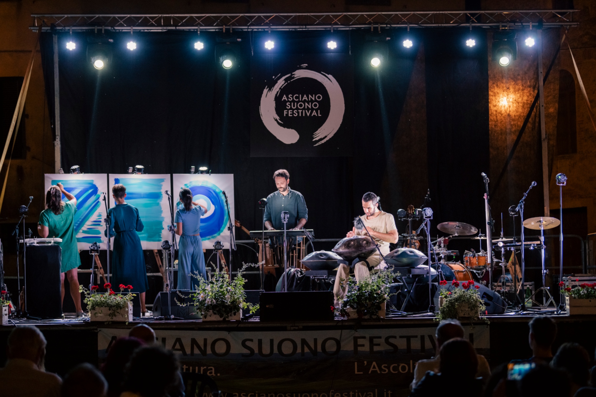 Un concerto serale della rassegna con due musicisti sul palco e tre artiste che dipingono alle loro spalle