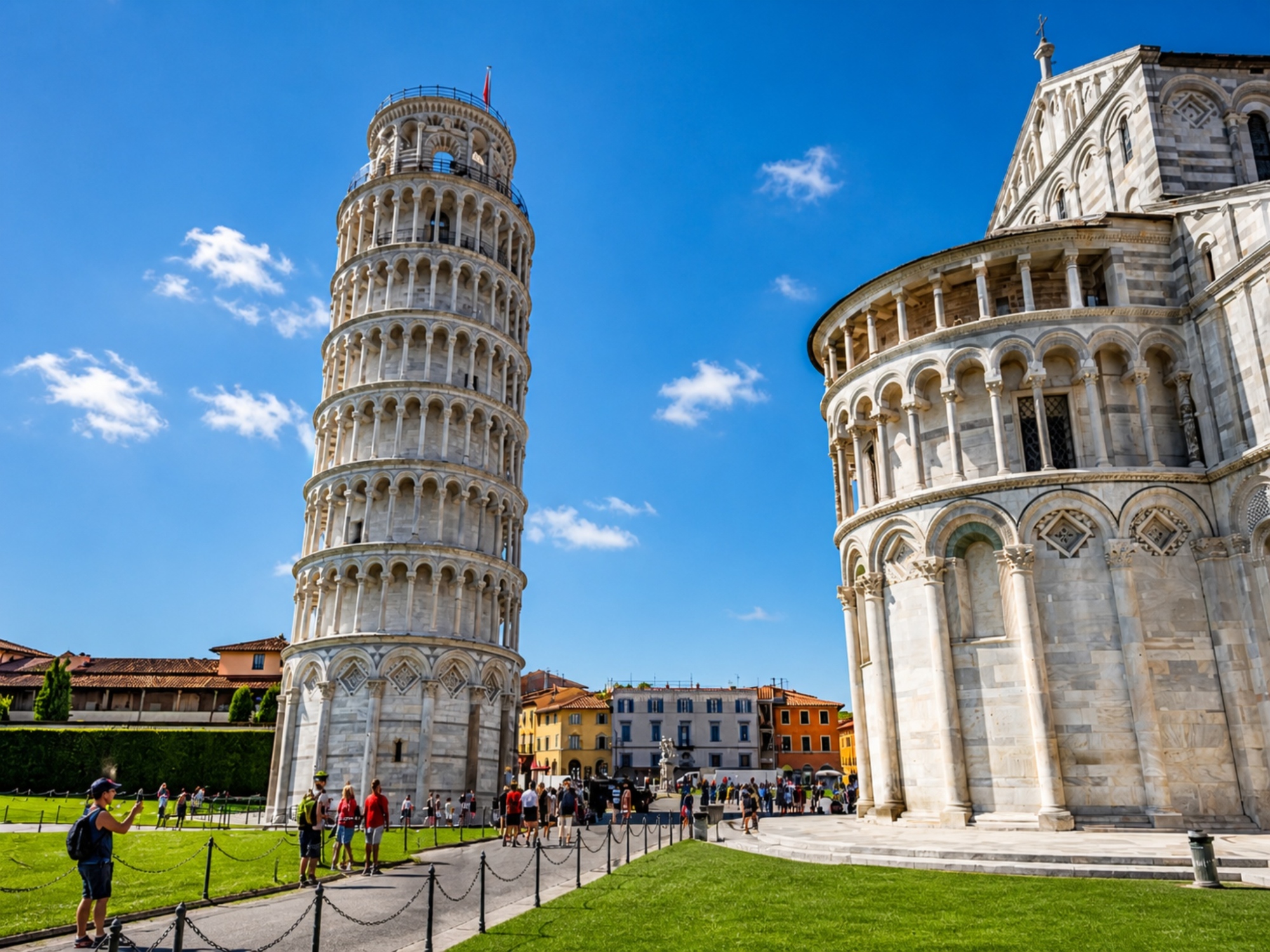 Torre Pendente e abside del Duomo di Pisa visti dalla piazza dei Miracoli con turisti