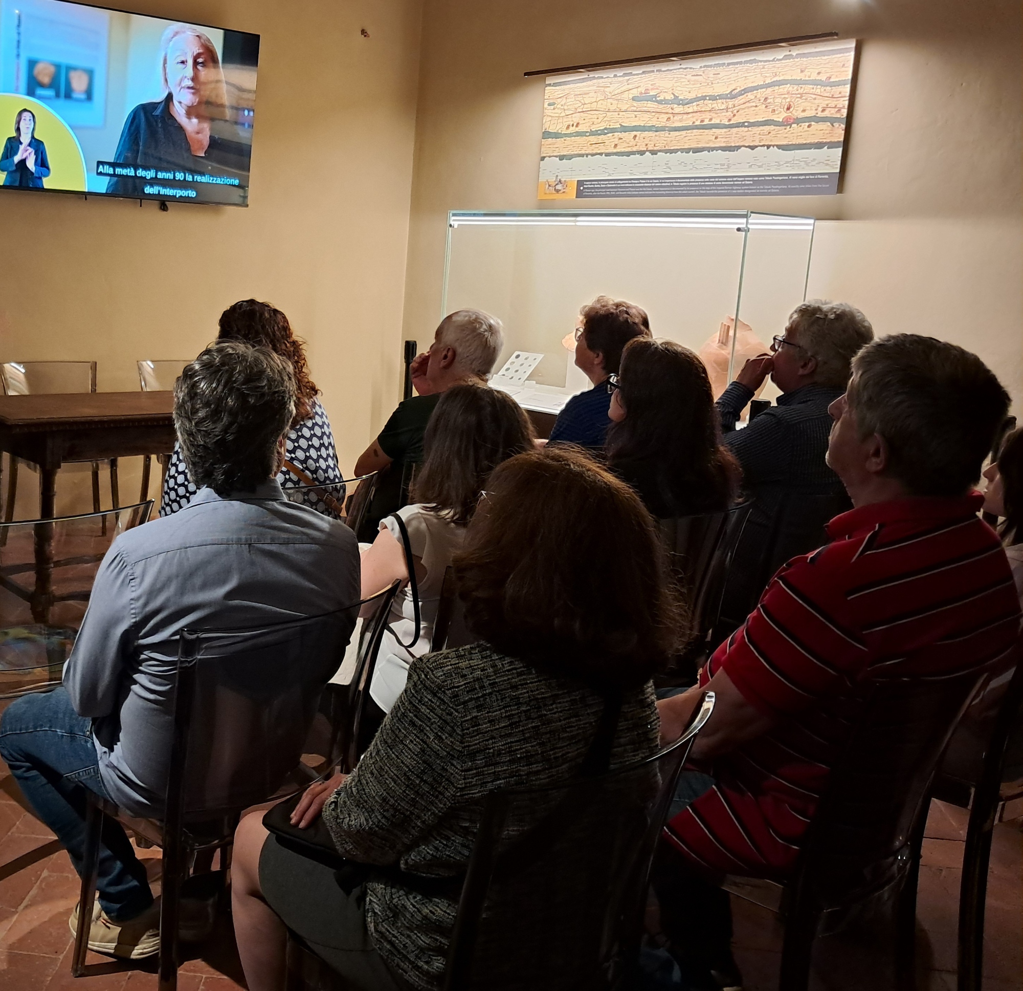 Un gruppo di persone sedute di spalle che seguono una conferenza