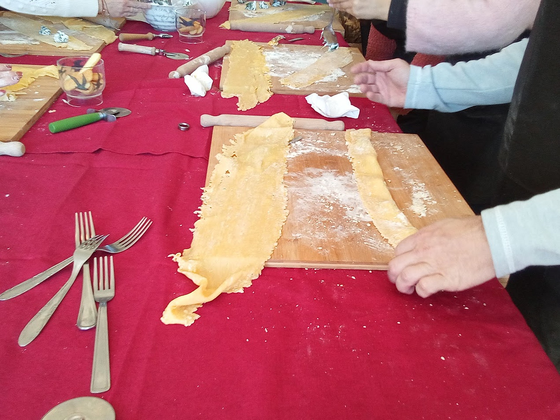 Sheets of fresh egg pasta laid out on wooden boards during a cooking class