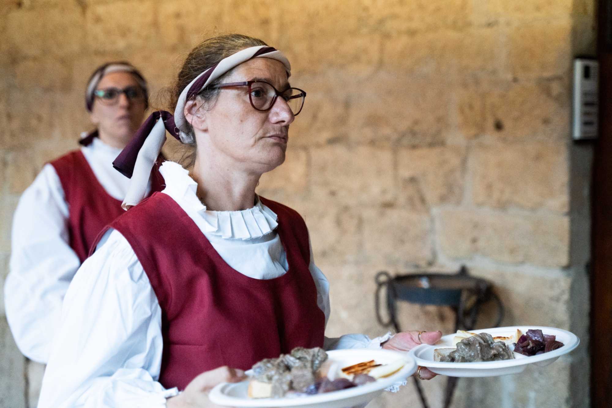 Immagine di una persona in costume che porta del cibo in tavola
