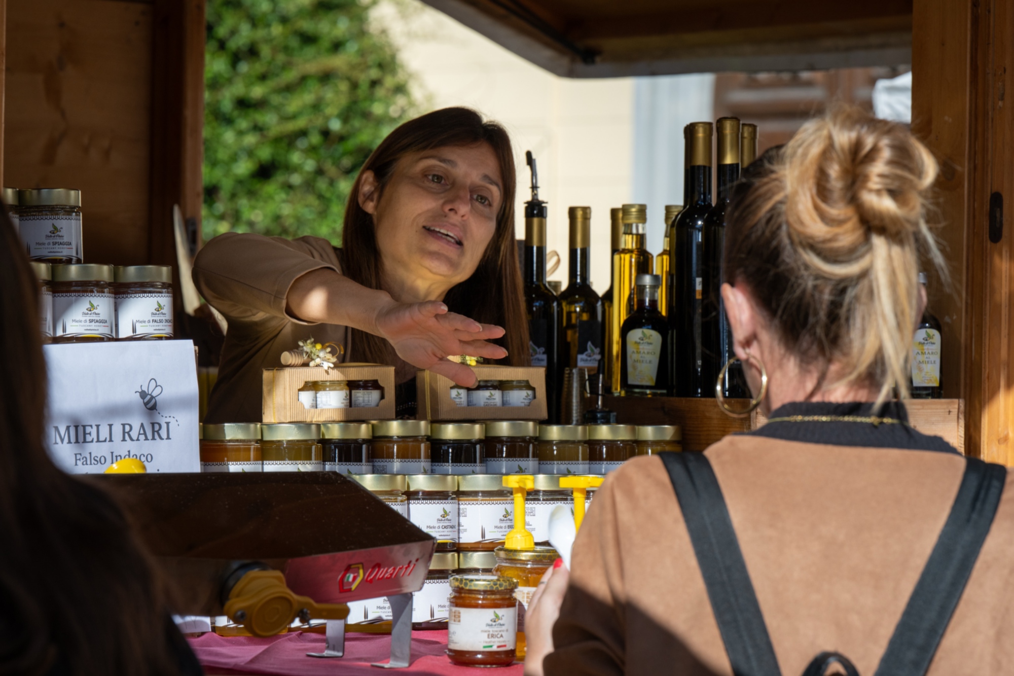 una signora assaggia il miele ad uno stand durante il festival di Pisa food & wine