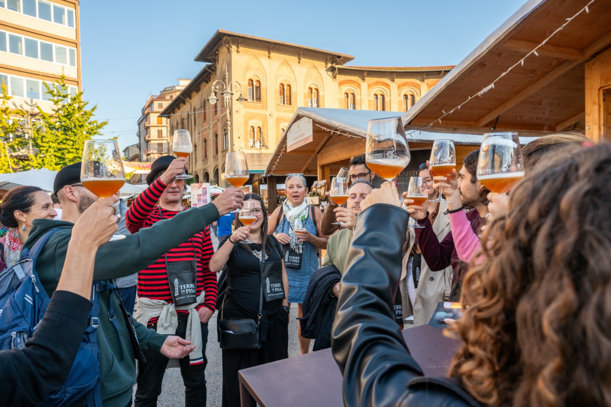 un gruppo di persone brinda durante una degustazione di vino al pisa food & wine festival