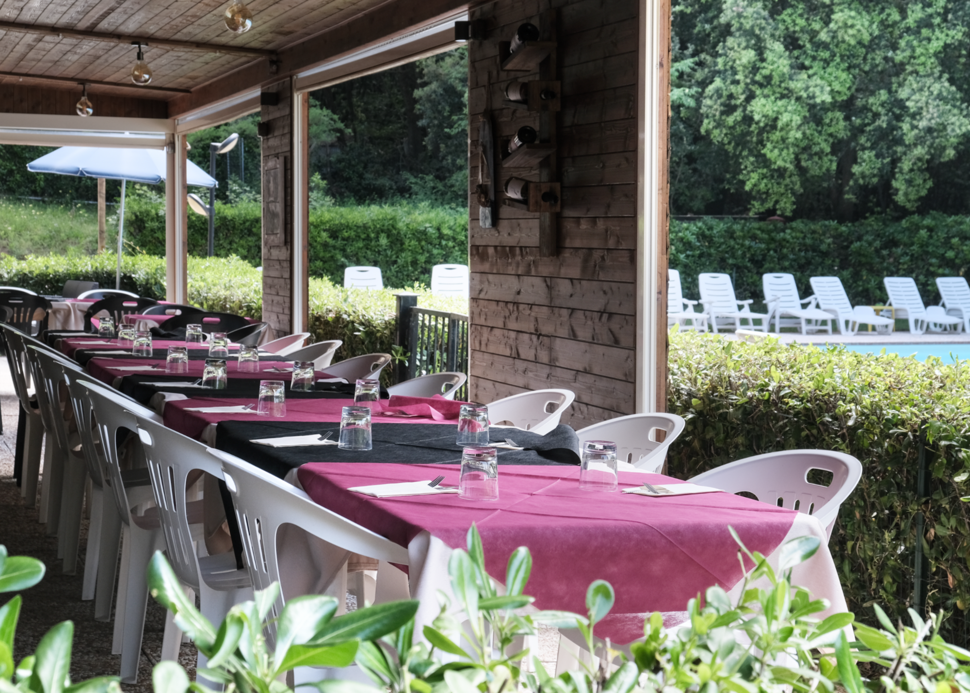 La sala ristorante con sedie e tavolini in plastica bianca del Residence il Paradiso sotto un porticato