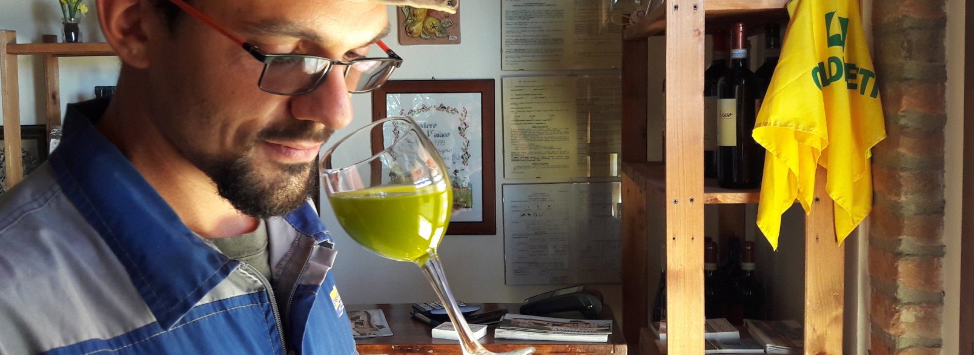 Gianluca Bassini farmer with a glass of his own organic extra virgin olive oil