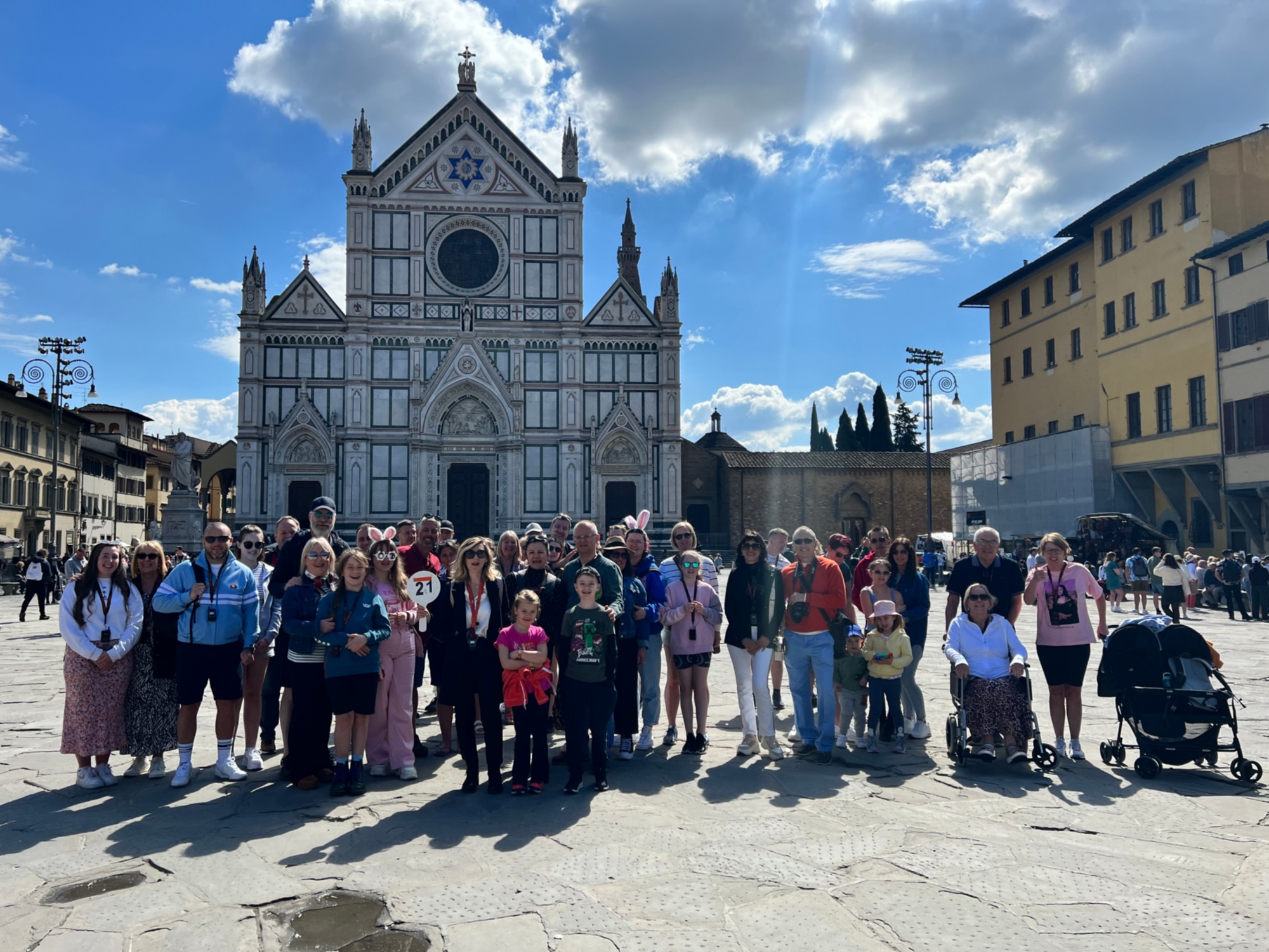 Gruppo di turisti in posa davanti alla Basilica di Santa Croce a Firenze