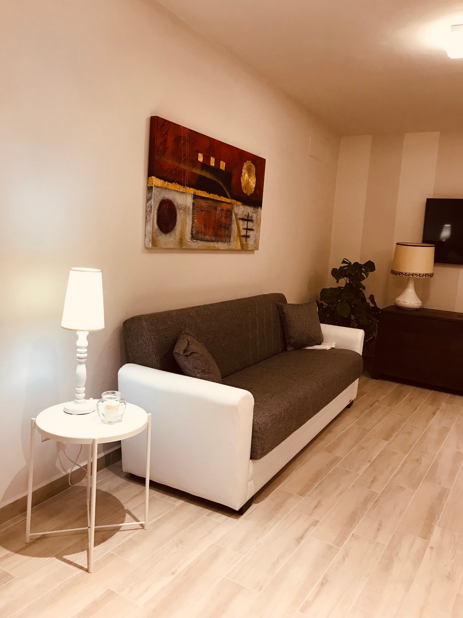 La zona giorno composta da un divano, mobilio nero e televisione