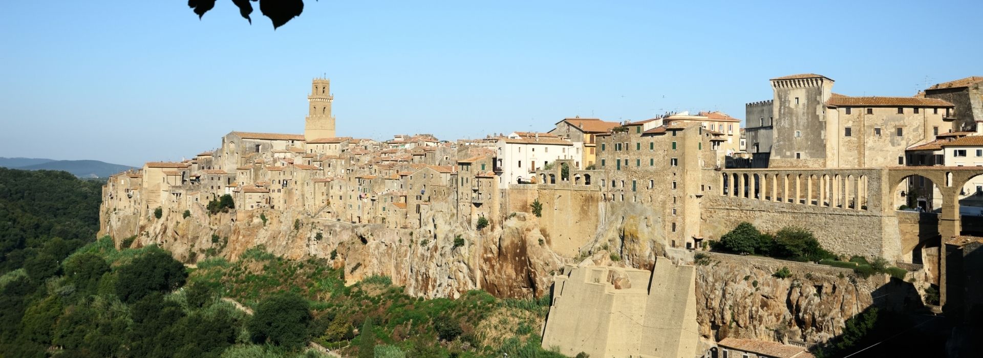Panoramic view of the village of Pitigliano perched on a tuff spur, with the clock tower, the Orsini Palace, and the Medici aqueduct, part of the five-day package in the Maremma tuff region
