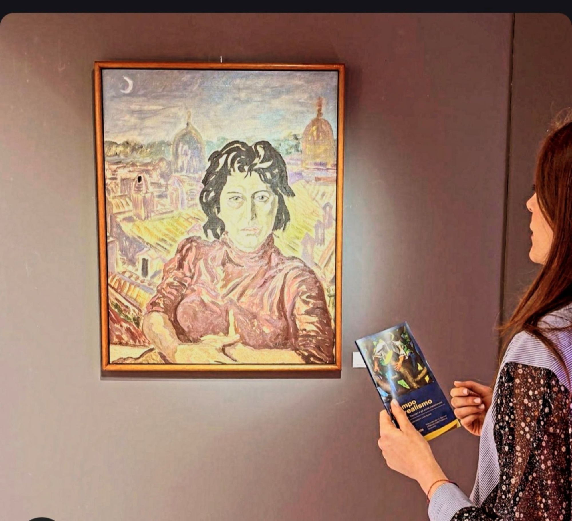 Immagine di una persona davanti ad un dipinto della mostra