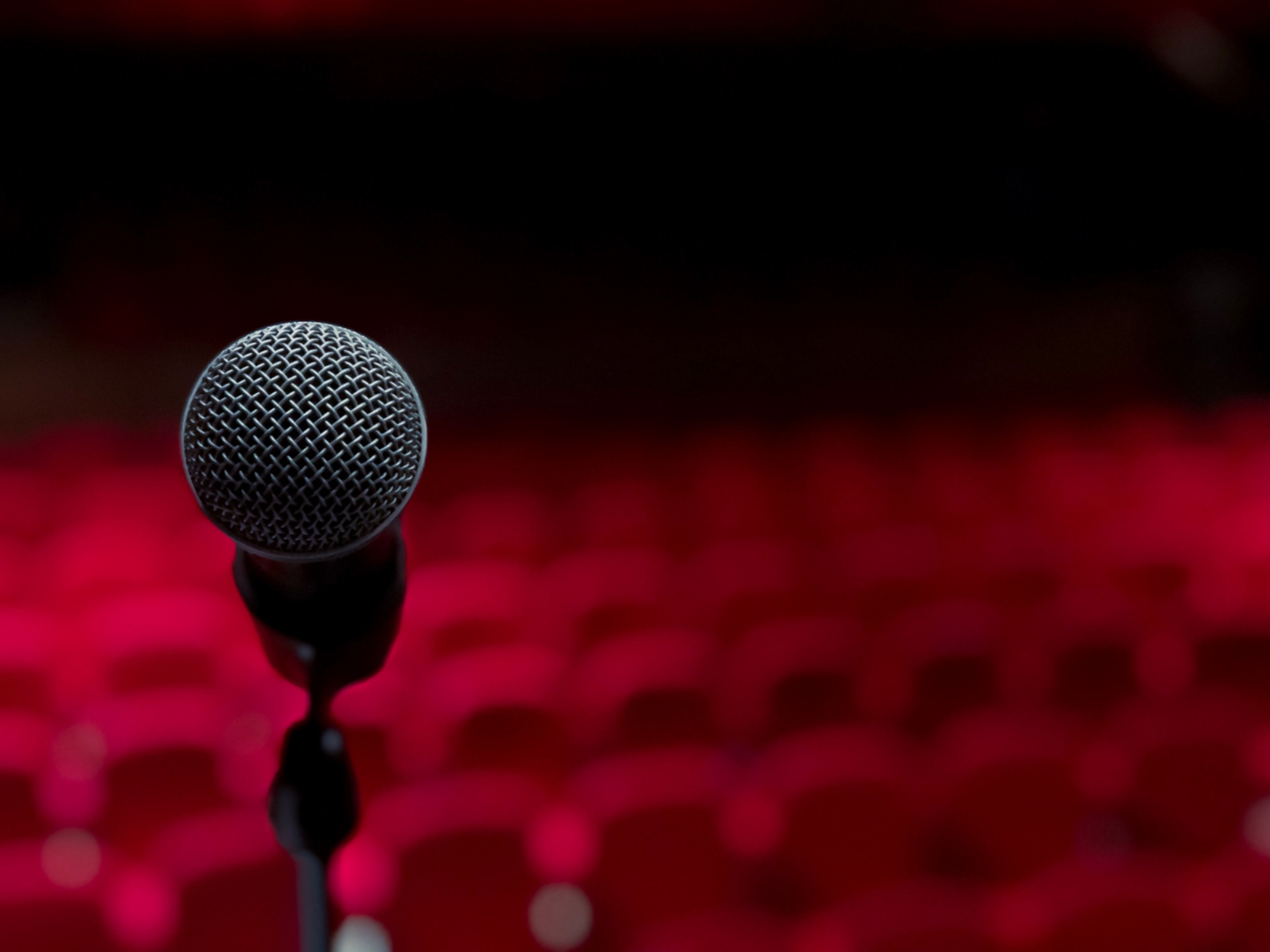 Immagine di un teatro vuoto con un microfono in primo piano