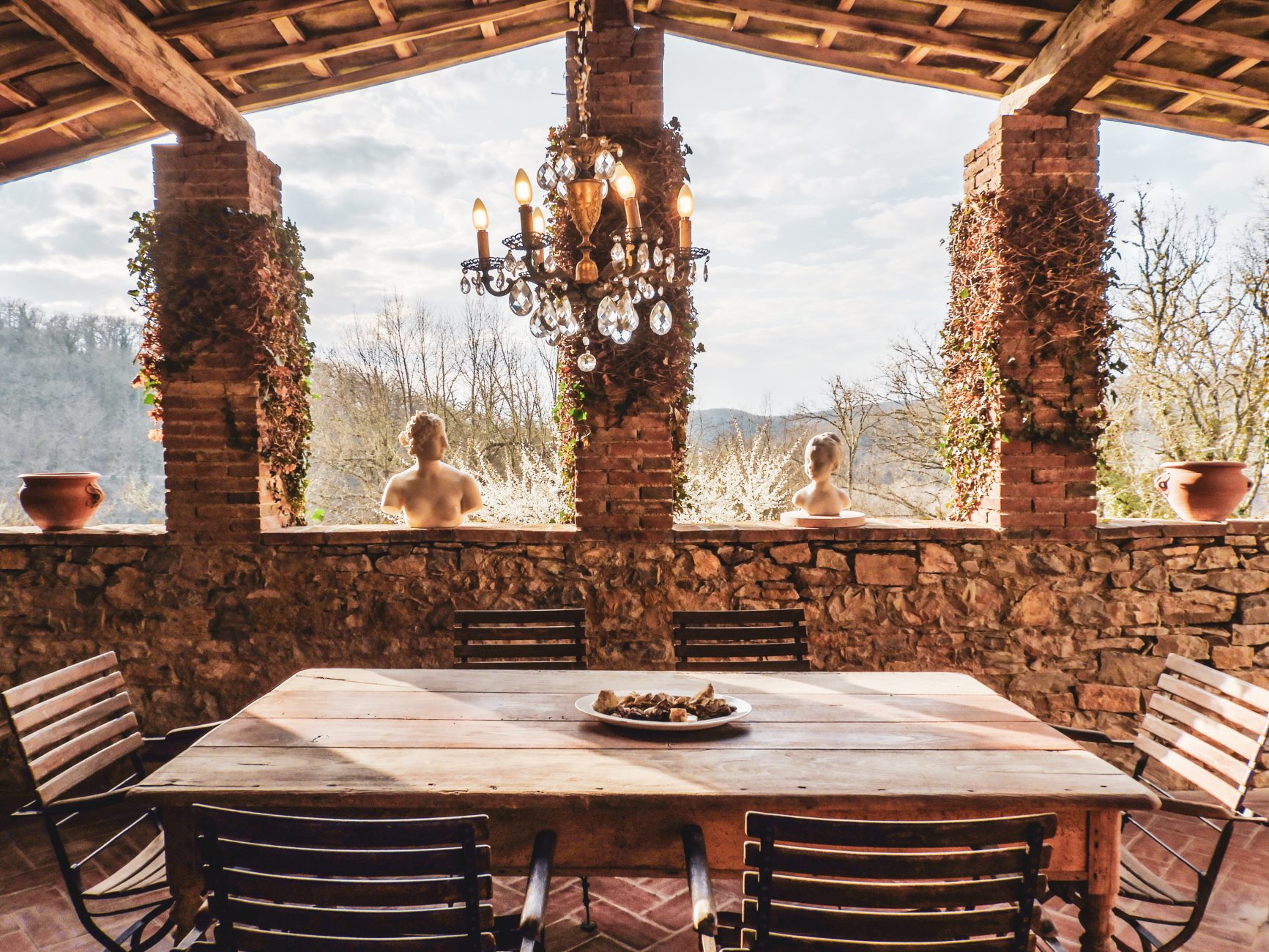 Il porticato dell'agriturismo CorteDomina con tavolo e sedie di legno