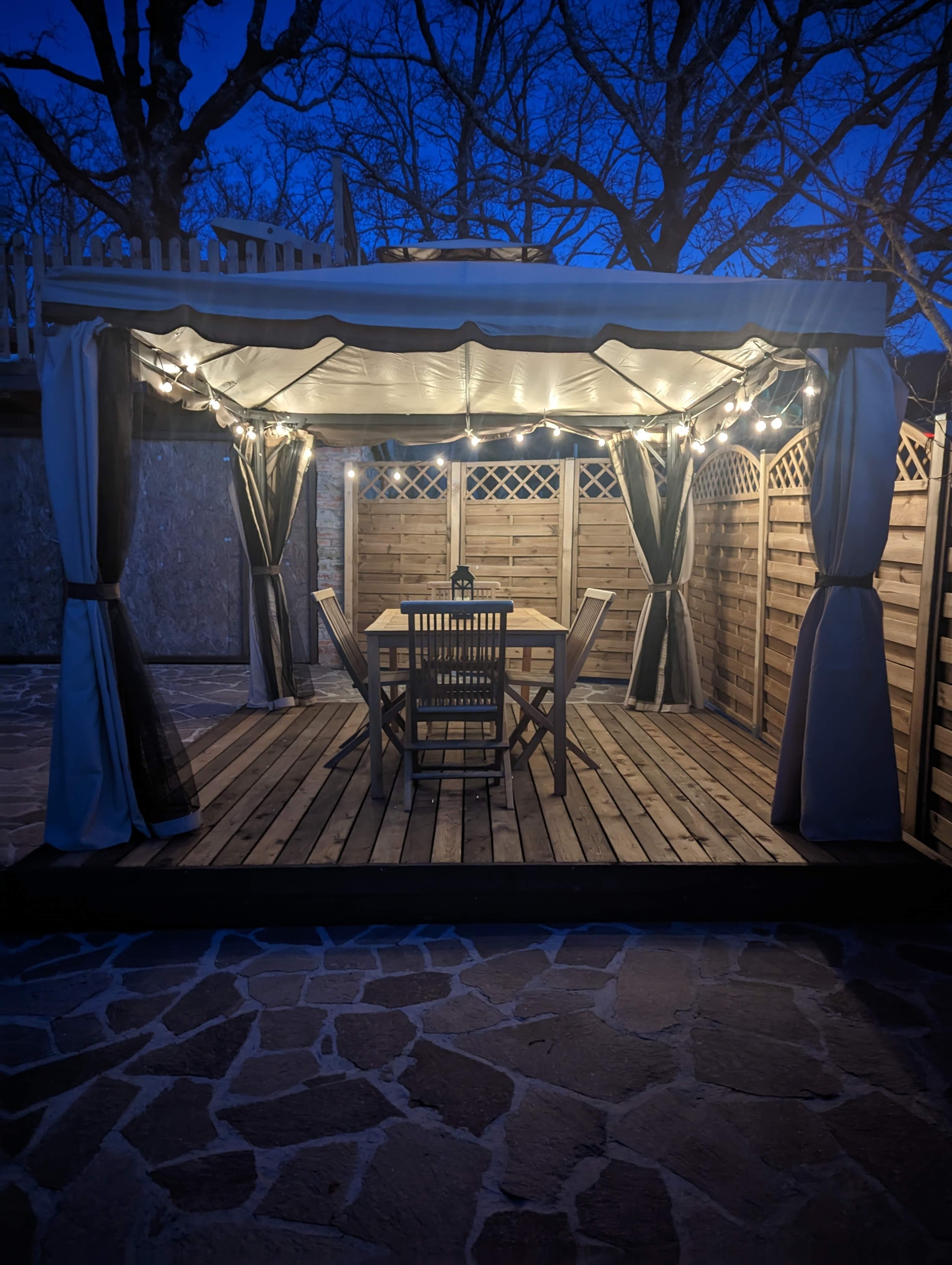 Il gazebo esterno attrezzato con tendaggi, tavolino e sedie