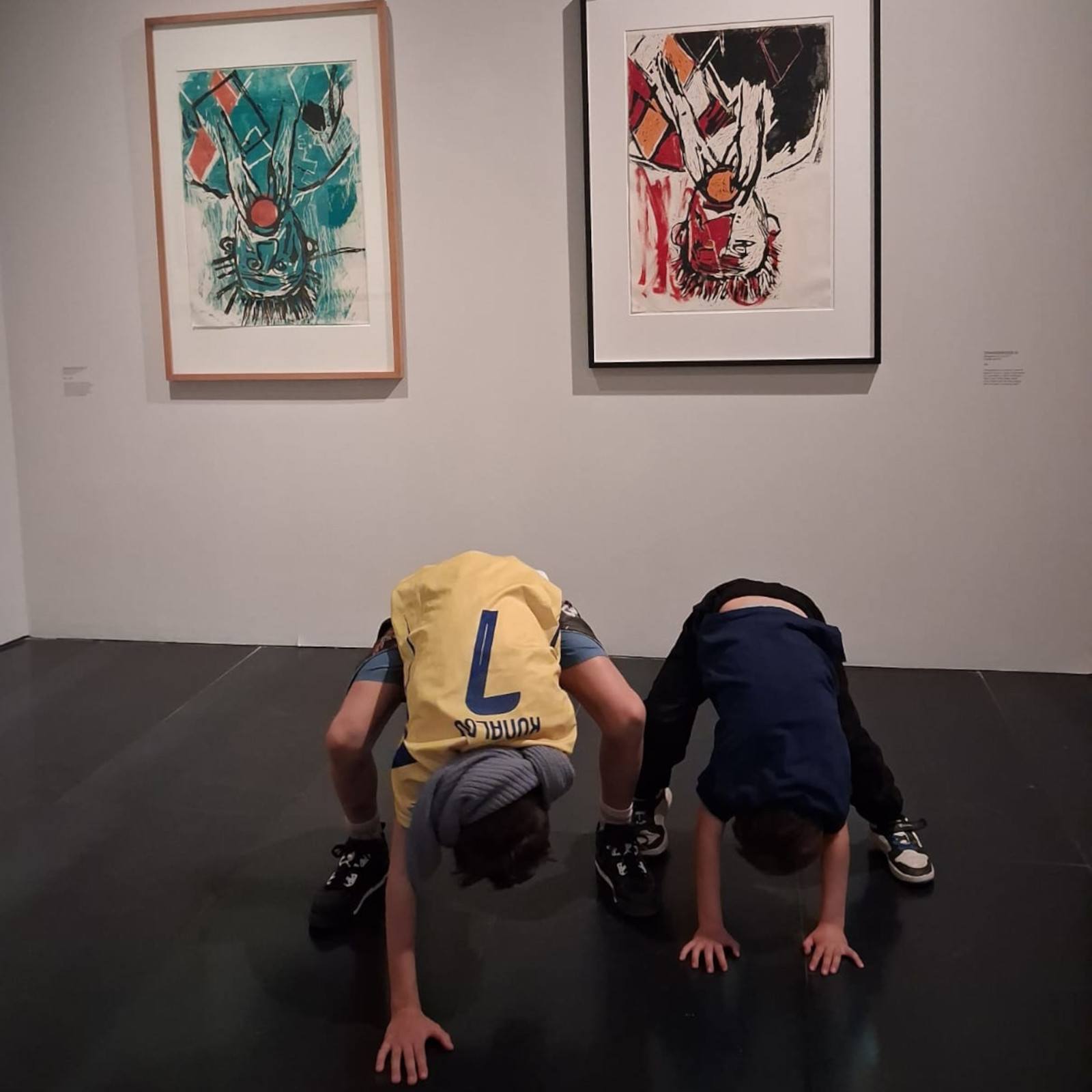 Momento di gioco davanti alle opere con due bambini che provano a capovolgersi