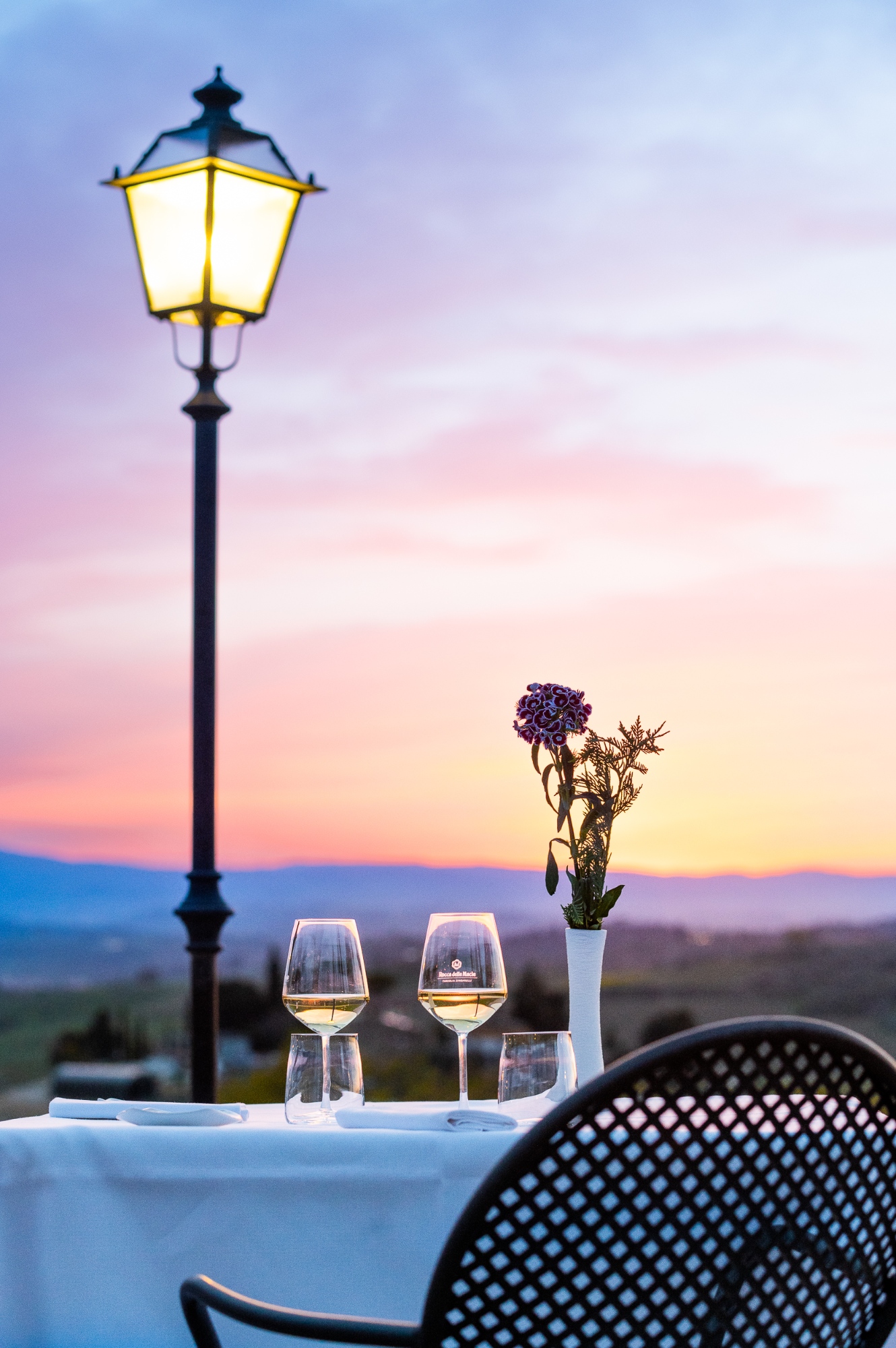 Un tavolino apparecchiato con un tramonto sullo sfondo