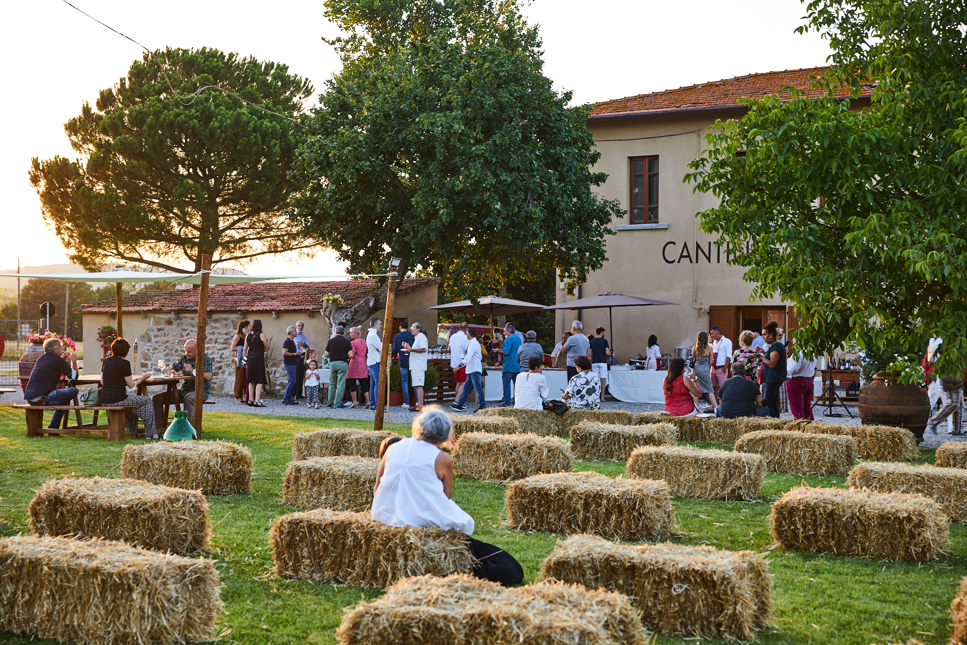 Immagine di una serata di degustazione su balle di fieno al tramonto