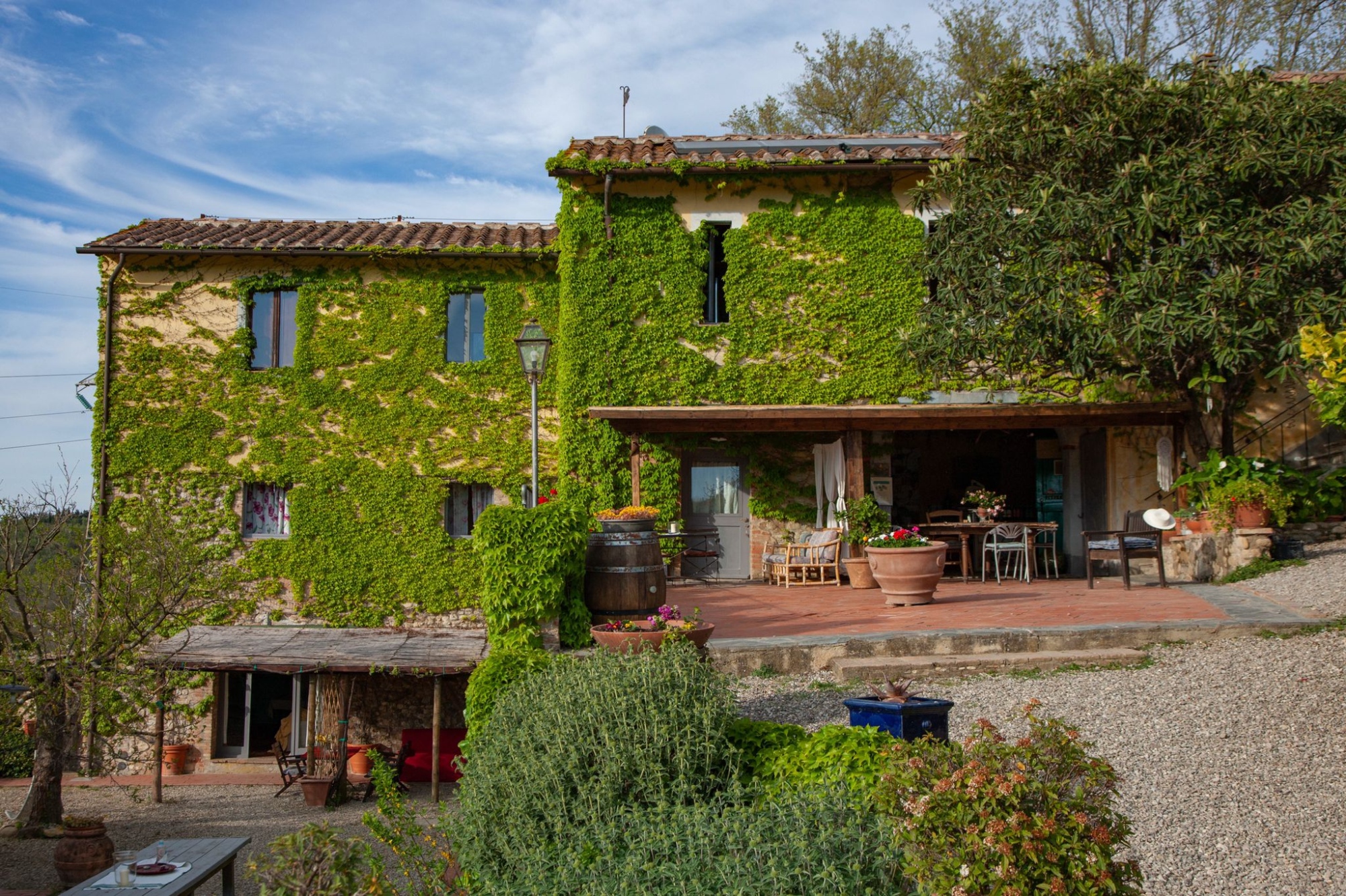 View of Agriturismo Il Bacio from afar with the facade covered in vegetation