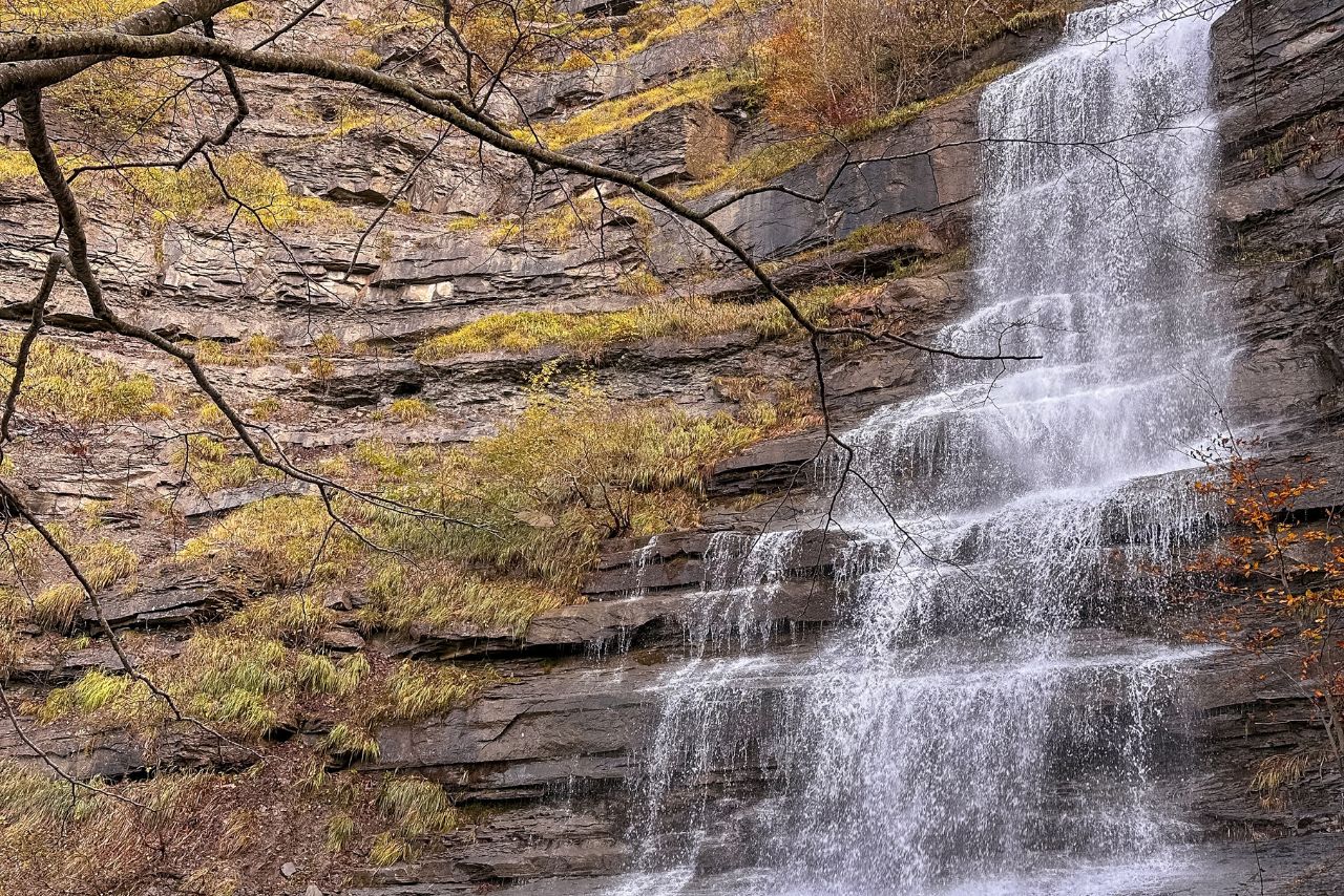 Salto d’acqua della Cascata del Piscino tra rocce e bosco.