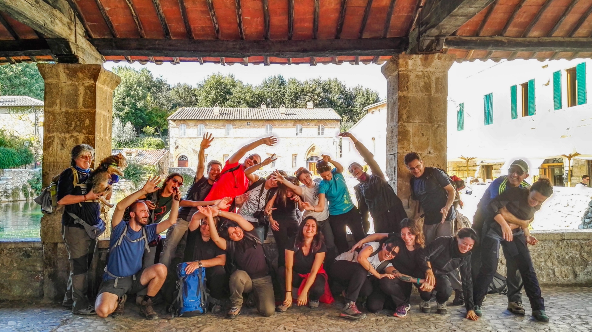 Gruppo di pellegrini in posa davanti alla storica vasca termale di Bagno Vignoni.