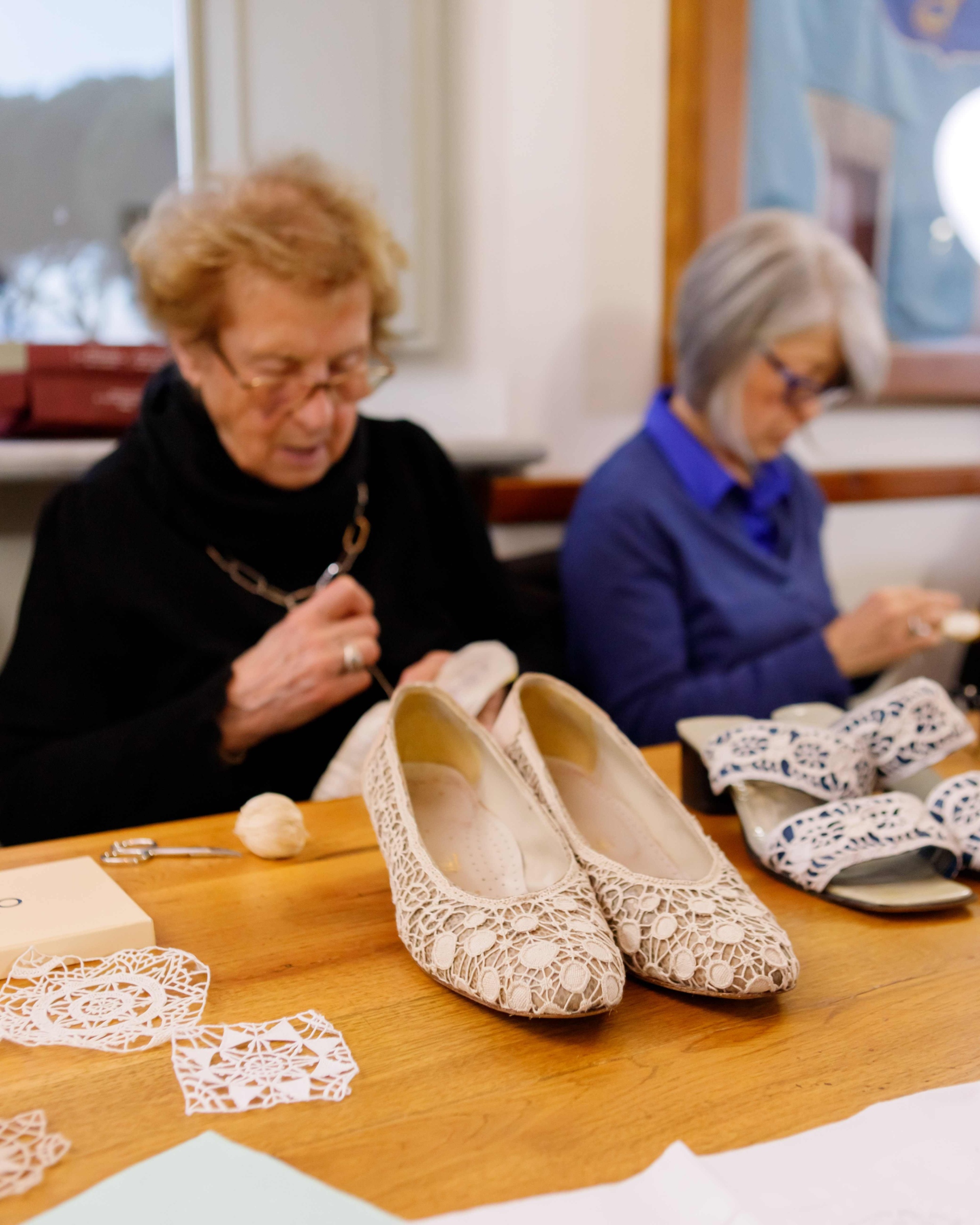 Ricamatrici del punto Tavarnelle al lavoro con un esempio delle loro creazioni